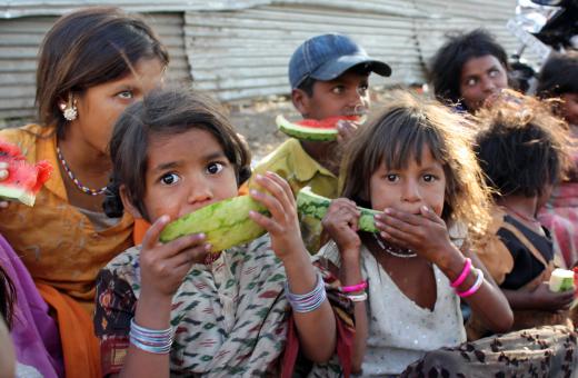 Impoverished children eating watermelon.